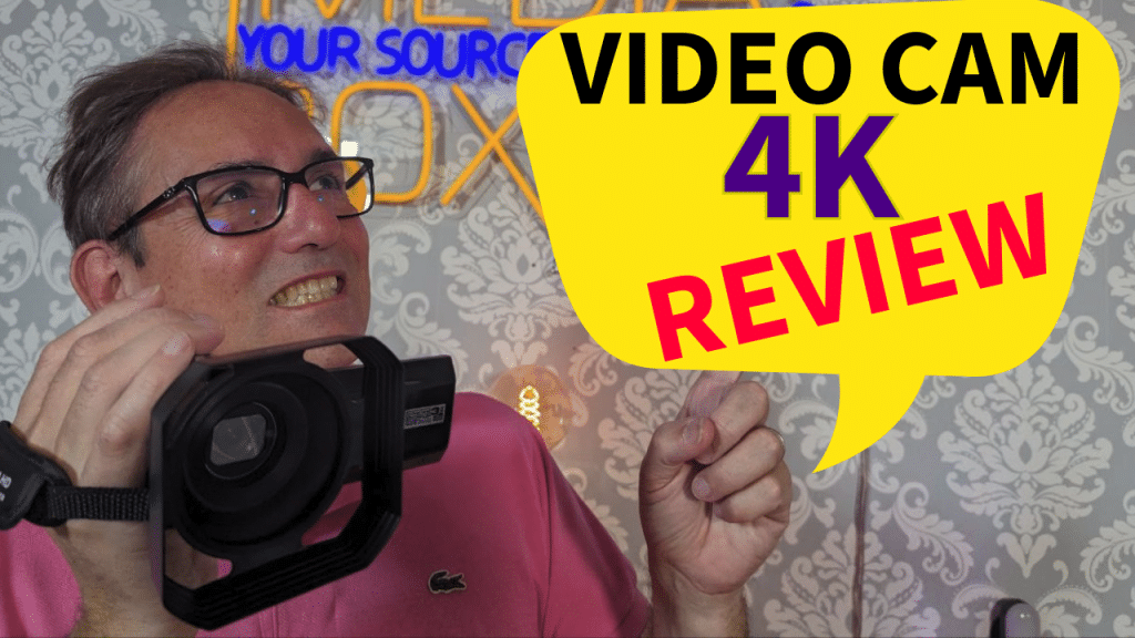 Enthusiastic man presenting a 4K video camera for a product review with a colorful graphic saying 'VIDEO CAM 4K REVIEW' in the background.