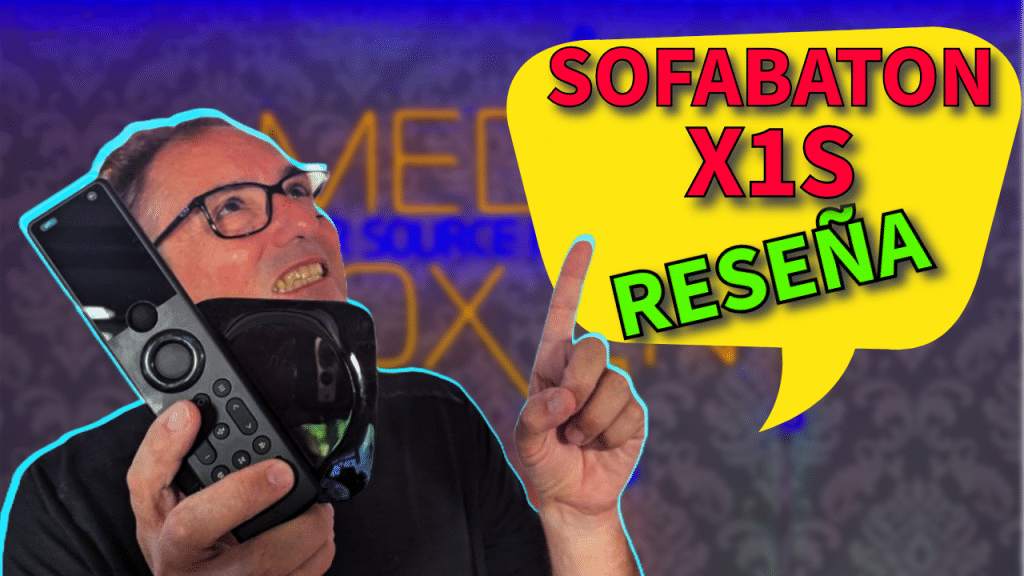 Hombre sosteniendo el control remoto Sofabaton X1S, señalando hacia arriba con el texto "SOFABATON X1S RESEÑA" en un bocadillo amarillo.
